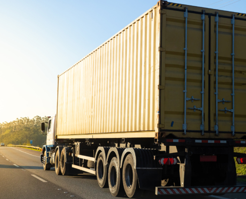 Yellow Shipping Container Being Hauled On A Truck